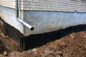 Waterproofing city flat house foundation wall. Waterproofing house foundation with bitumen